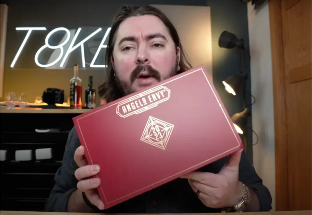 A man holding a Cask Mailer during an Unboxing video