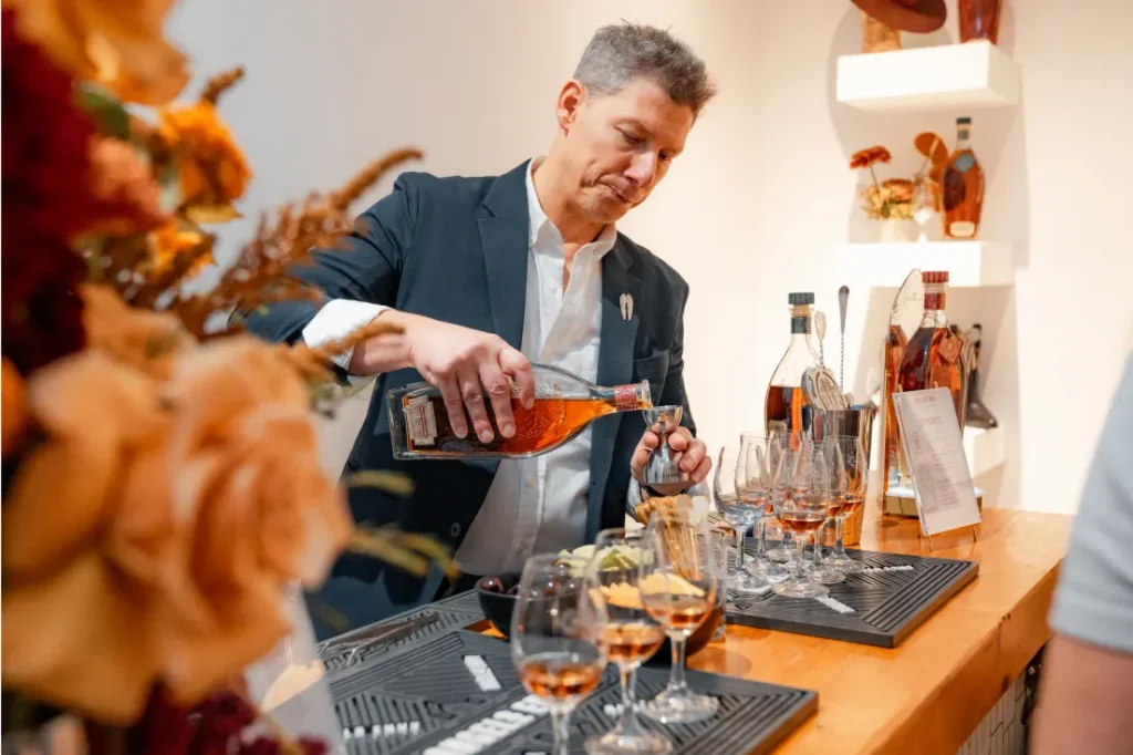A man in a suit pouring Angel’s Envy